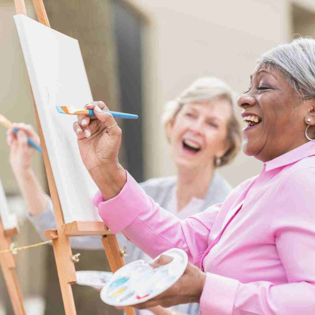 Two female seniors doing art classes outdoors